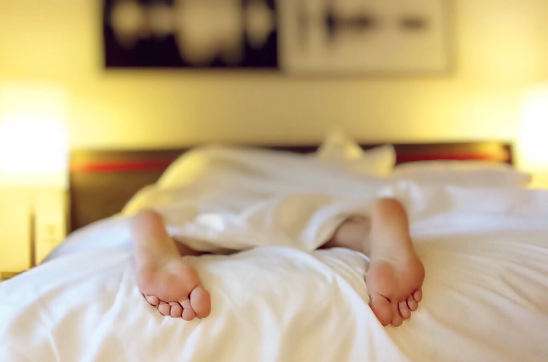 Sleeping person's feet viewed from the bottom of a bed